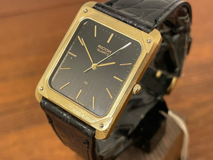 (1977) Ricoh 702009 quartz "Tank" dress watch - black dial w/ gold markers (NOS)