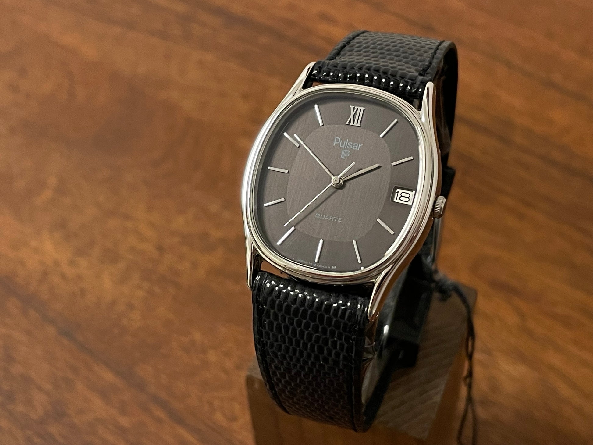 Front side (1982) Pulsar Y112-5099 "Ellipse" dress watch - silver case - black dial w/ silver stick markers (NOS)