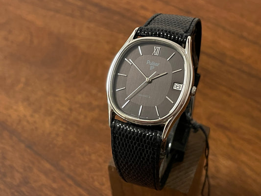 Front side (1982) Pulsar Y112-5099 "Ellipse" dress watch - silver case - black dial w/ silver stick markers (NOS)