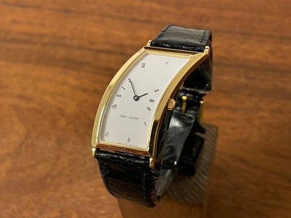 front side (1988) Cleto Munari "Parentesi" by Hans Hollein - asymmetrical 18K gold electroplated case - white dial w/ Roman numerals  (NOS + full set)
