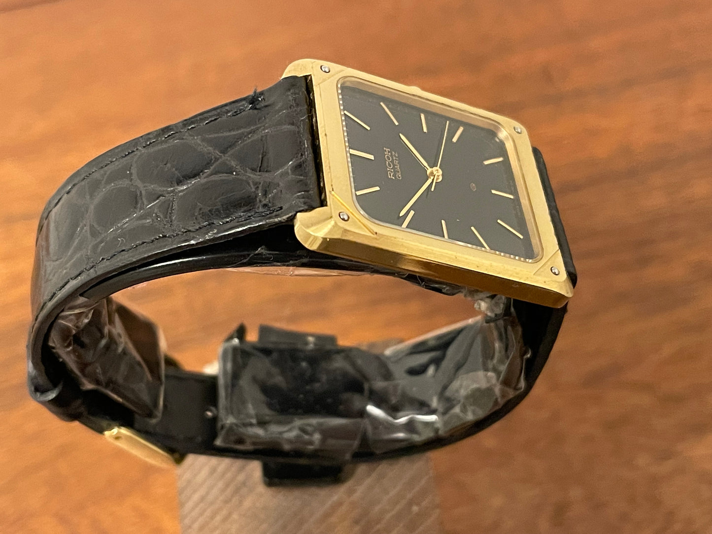 (1977) Ricoh 702009 quartz "Tank" dress watch - black dial w/ gold markers (NOS)