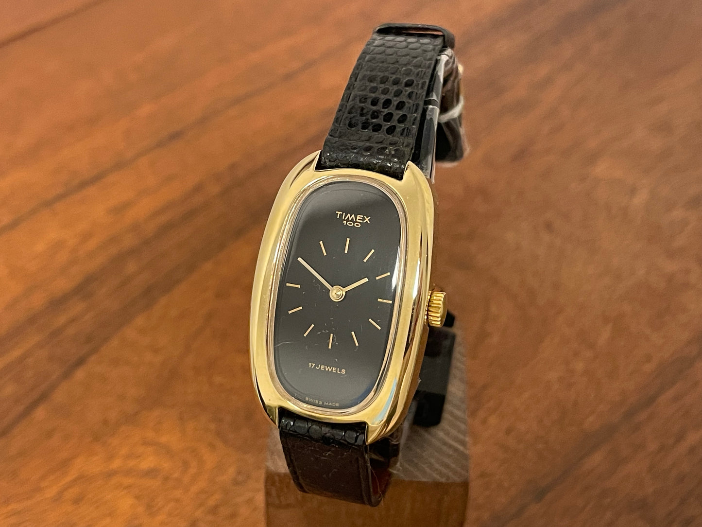 Front side (1979) Timex 100 manual wind dress watch - Swiss made - tonneau case - black dial w/ gold markers