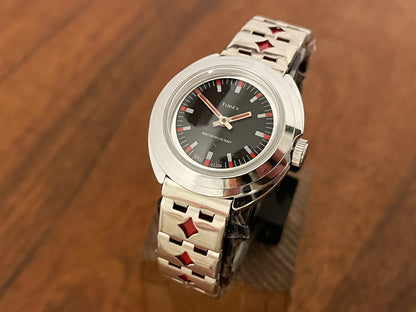 Front side (1970s) Timex 509-528 dress watch - silver case - black dial w/ silver & red markers - small size (NOS + full set)