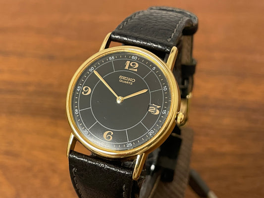 Front side (2000) Seiko 5Y39-7010 dress watch - gold colored case - black dial w/ flat gold Arabic numerals (NOS)