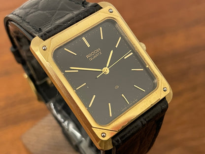 (1977) Ricoh 702009 quartz "Tank" dress watch - black dial w/ gold markers (NOS)