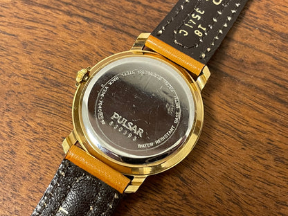 (1988) Pulsar V336-7040 dress watch - gold colored case - creme dial w/ Arabic numerals