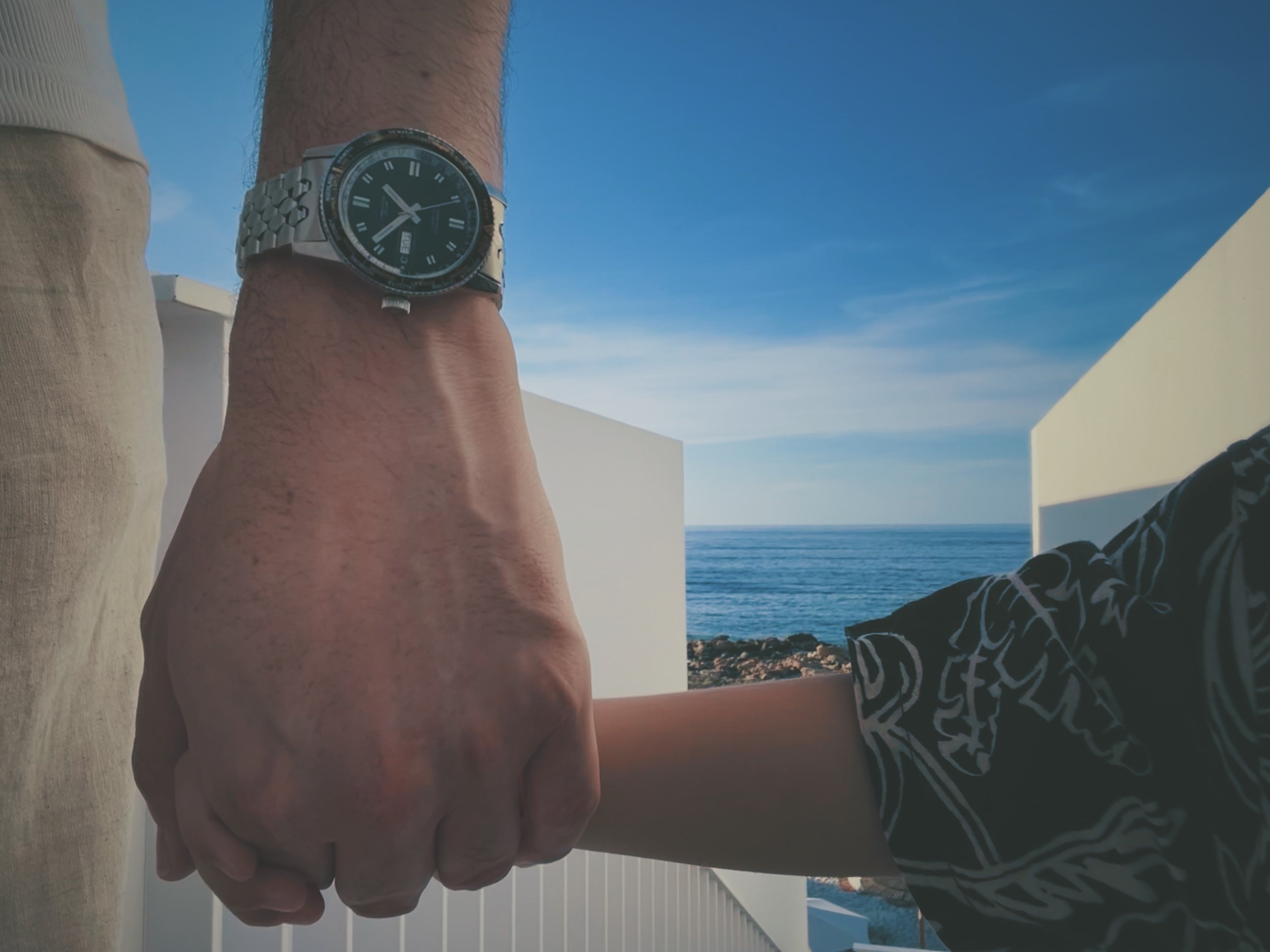 Father and son holding hands while father is wearing a vintage wristwatch