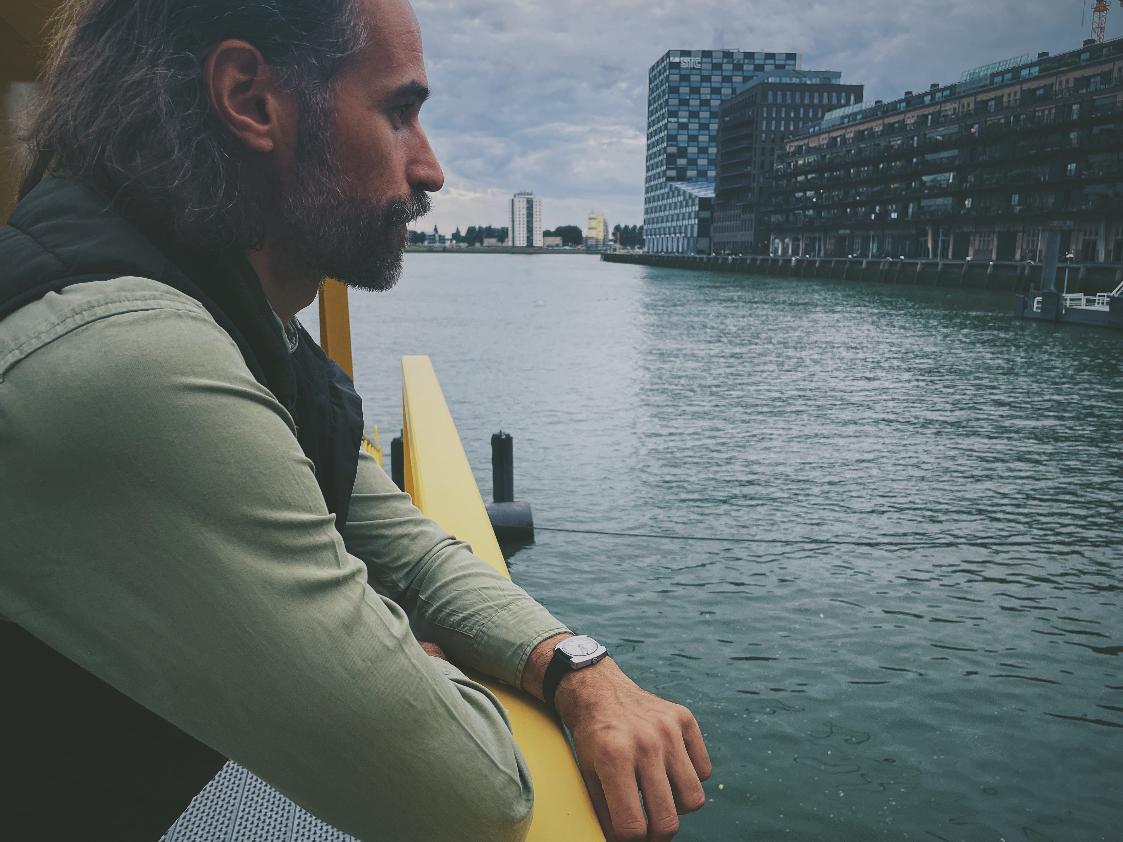 Man standing besides the dock wearing a vintage watch