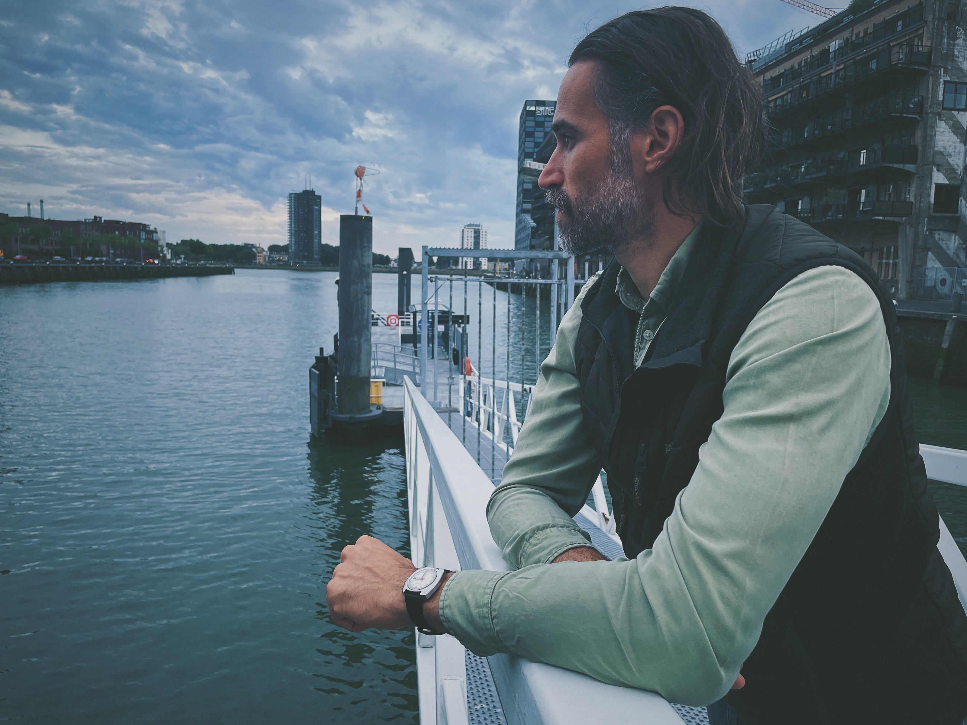 Man wearing a vintage wristwatch overlooking the water